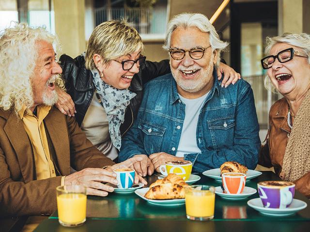 Group of older friends having fun in rooftop restaurant
