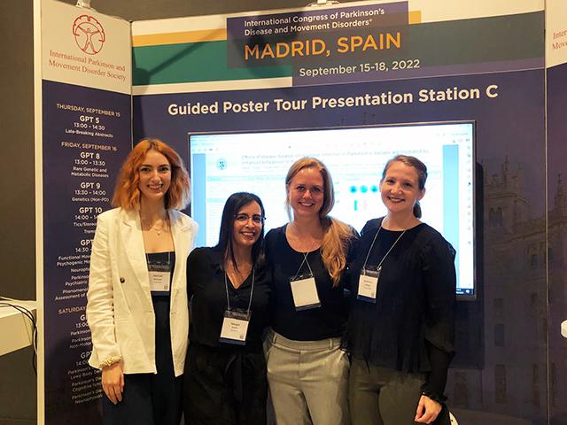 Four women standing in a booth at a scientific conference
