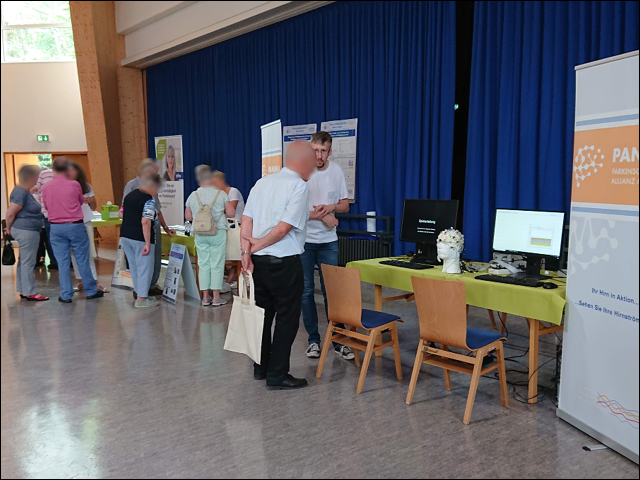 Seven people with faces blurred at a Parkinson's disease outreach event 