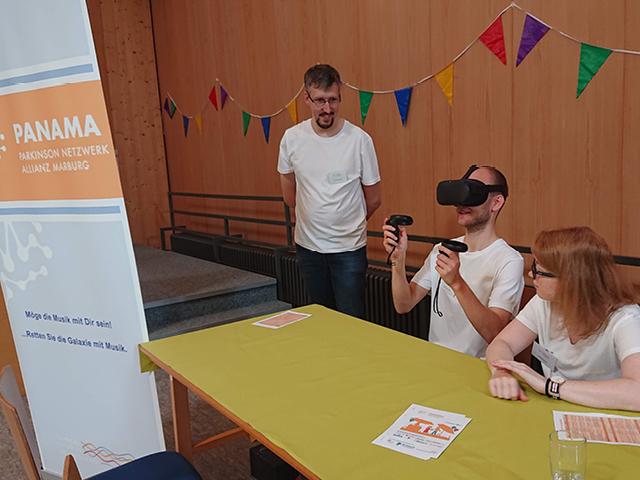 Principal Investigator Dr. Immo Weber presenting his virtual reality paradigm to PhD candidate Johannes Busch and undergraduate student Carina Robert at our outreach event for Parkinson's disease patients in Germany